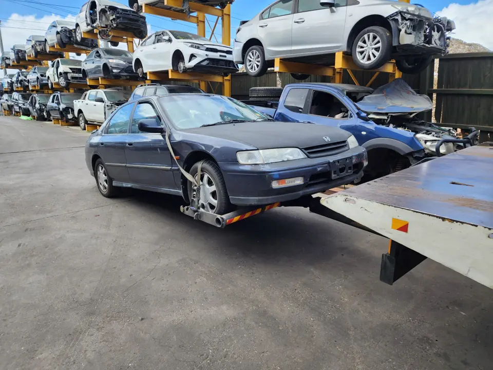 Dark sedan beside a flatbed truck
