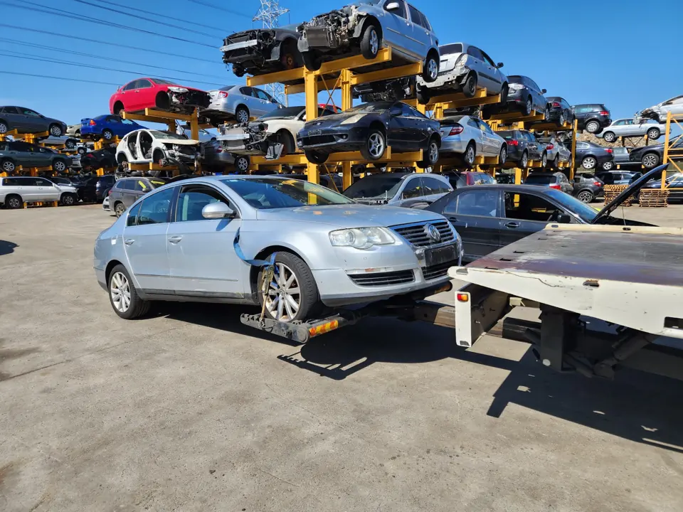 Silver sedan near other yard vehicles