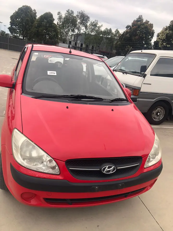 Red hatchback in a vehicle yard