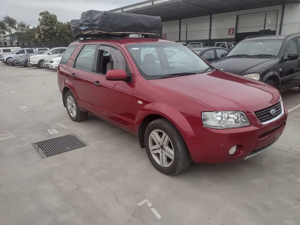 Red SUV with roof-mounted luggage