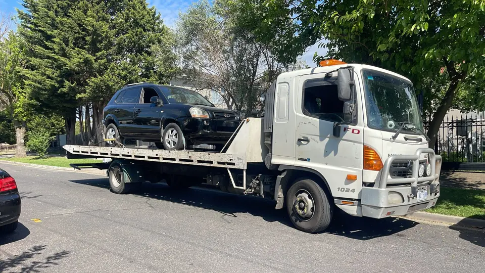 Flatbed truck carrying a vehicle