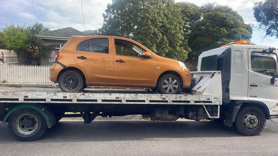 Orange hatchback on a flatbed