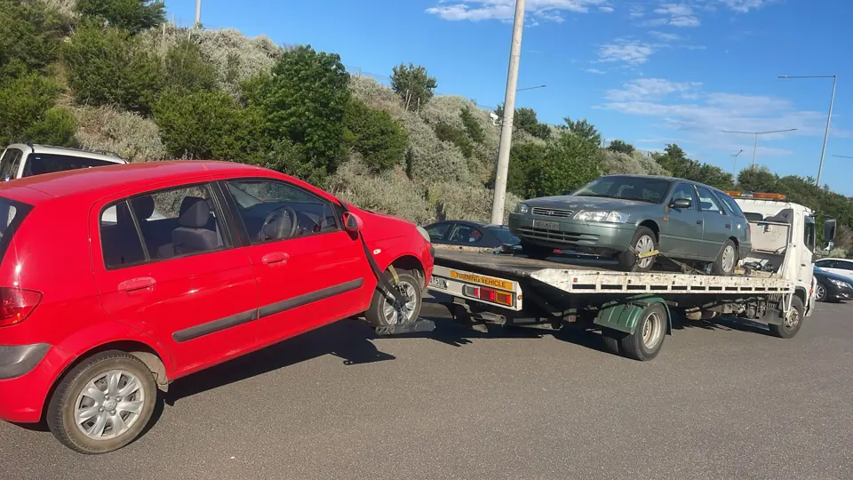 Red hatchback beside other vehicles