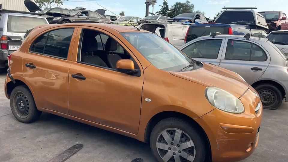 Orange hatchback parked in a yard