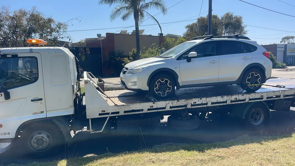 White SUV secured on a truck