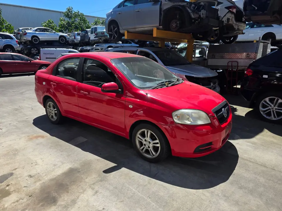Red hatchback in a vehicle yard