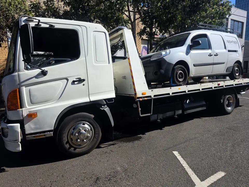 White vehicle loaded on a truck