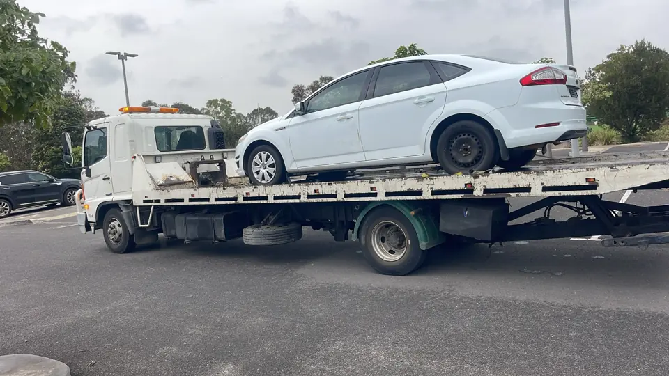 White sedan on a transporter