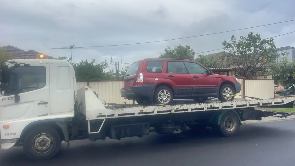 Red SUV on a recovery truck