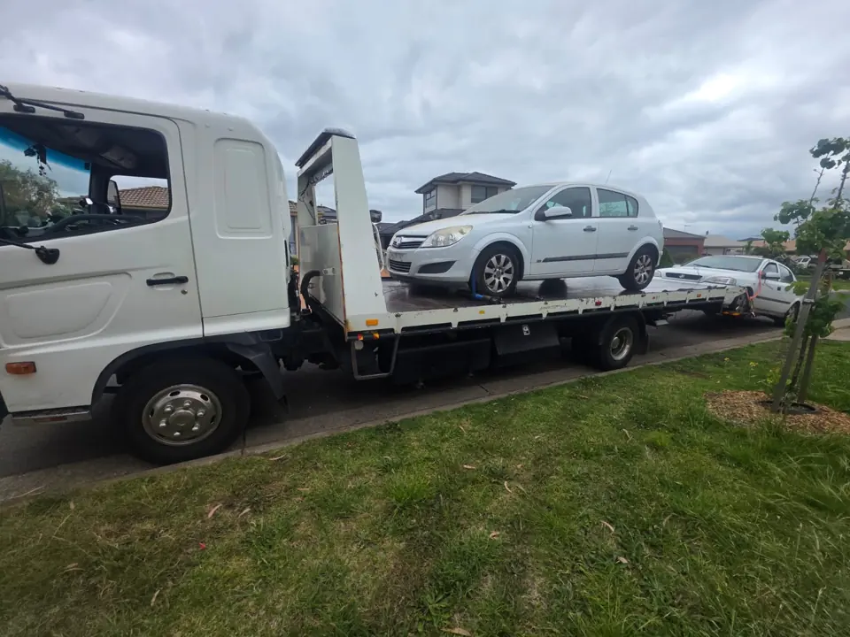 White truck carrying a vehicle